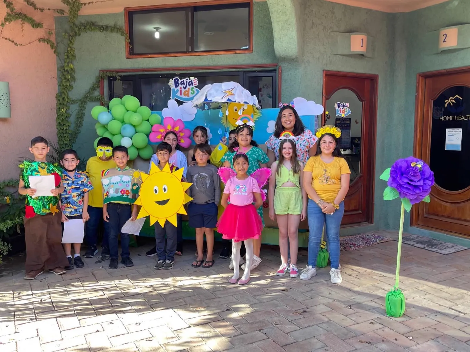 Grupo de niños con Ilse celebrando una actividad temática en Baja Kids