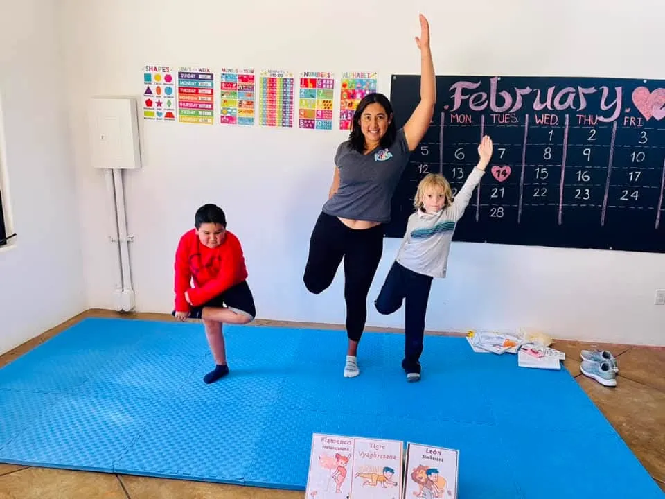 Ilse y dos alumnos practicando equilibrio durante una clase de yoga infantil